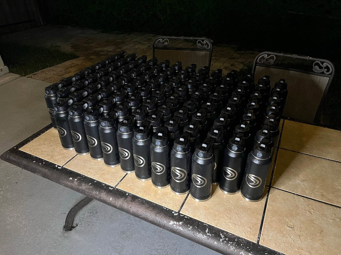 A large production order of black bottles engraved with matching customer logos