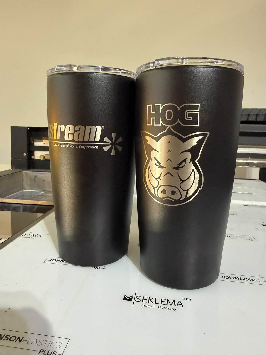 Two black tumblers with laser engraved business logos